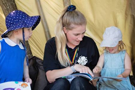 A practitioner reading a story to two children