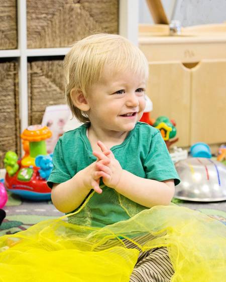 A child smiling brightly during creative play
